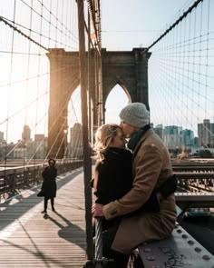 a man and woman hugging on the brooklyn bridge