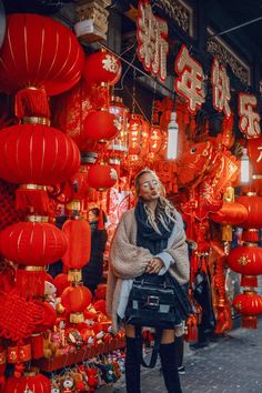 a woman standing in front of red lanterns