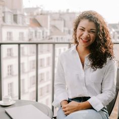 a woman sitting on top of a chair next to a table