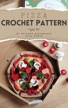 a pizza in a box with crochet on the top and other items around it