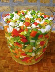 a glass bowl filled with vegetables on top of a wooden table