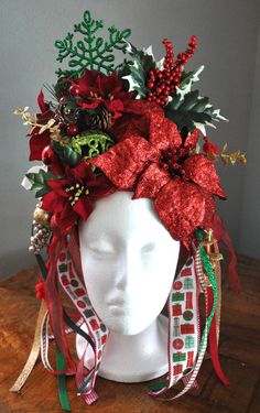 a white mannequin head wearing a red and green christmas wreath on top of it