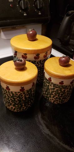 three yellow and brown containers sitting on top of a stove