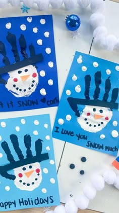 three handprinted snowman cards on a table