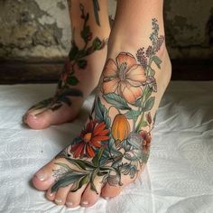 a woman's foot with flowers and leaves on it