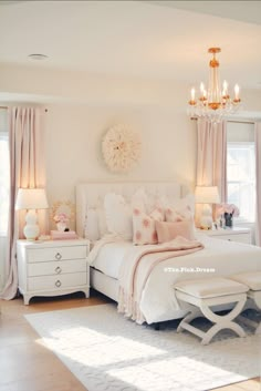 a bedroom with white furniture and chandelier