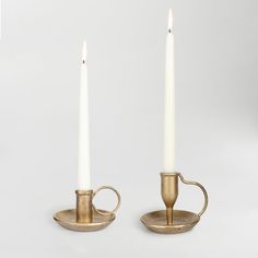 two candles sitting on top of each other with one candle in the middle and another burning