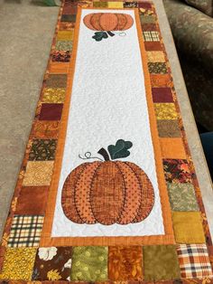 a quilted table runner with pumpkins on it