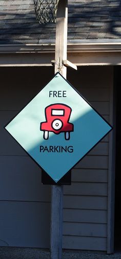 a free parking sign is hanging on the side of a house in front of a basketball hoop