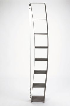 a metal book shelf sitting on top of a white floor