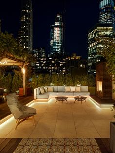 an outdoor seating area with city lights in the background