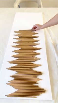 a person is placing sticks in the shape of a tree