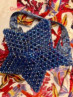 a blue purse sitting on top of a table covered in lots of different colored fabric