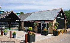 an outside view of a flower shop with potted plants