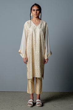 Ivory and gold screen printed pheran with hand embroidered detail. Paired with solid pant.
Components:2
Pattern:Embroidered, Printed
Type of Work:Cutdana work, Mirror work, Screen print
Neckline:V neck
Sleeve Length:Full sleeves
Fabric:Cotton satin, Georgette
Color:White,Gold
Other Details:
Cutdana and mirror work kurta
Flared sleeves
Occasion:Reception - Aza Fashions Kashmiri Pheran, Cutdana Work, White Kurta, Stylish Dress Book, Indian Fashion Designers, Jacket Pattern, Kurta Set, Pant Set, Set For Women