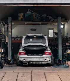 a car is parked in the garage with its hood up and it's trunk open