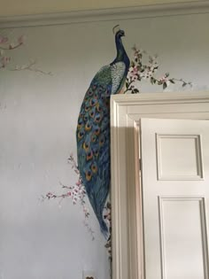 a peacock painted on the wall next to a door