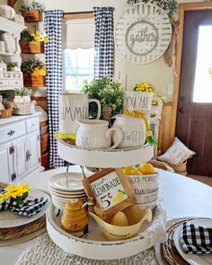 a table topped with plates and bowls filled with food on top of each other next to a window