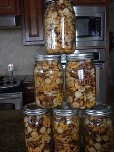 a stack of jars filled with nuts on top of a counter