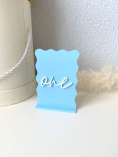 there is a blue card with the word one on it next to a white lamp