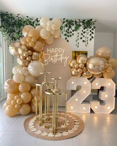 a birthday party with balloons and lights on the floor in front of a sign that says happy birthday