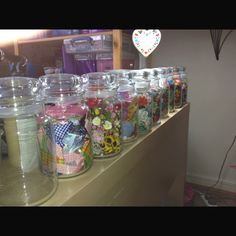 there are many jars on the counter with different things in them and one has a heart shaped balloon