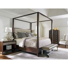 a four poster bed in a bedroom with white walls