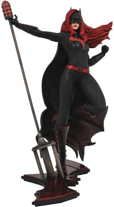 a statue of a woman dressed as batgirl on top of a sled with her arms outstretched