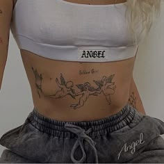 a woman's stomach with tattoos on it and the words angel above her belly