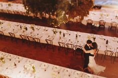 a bride and groom standing next to each other in front of tables