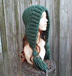 "Style: Bonnet style hood with fluffy oversized tassels. Color: This sample hat is shown in Kale ..green with tweed. You can choose from 34 colors. Please see the last photo in the listing and zoom in for a visual reference of your color choices, then select it from the drop down menu when ordering. Sizes: One size fits 20\" to 23\" (50.5 cm to 58 cm) head size. Fiber Content: 80% acrylic, 20% Wool Characteristics: Whimsical, very soft, warm and cozy. Care Instructions: Hand wash, dry flat. Ever Chunky Crochet Hat, Bonnet Au Crochet, Crochet Hood, Flap Hat, Earflap Hat, Mollie Makes, Ear Flap Hats, Mens Hat, Pixie Hat