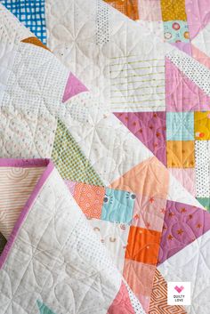 a close up of a colorful quilt on a table top with text overlay that reads how to make a patchwork quilt