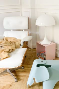 an elephant shaped table sitting next to a white chair and lamp in a living room