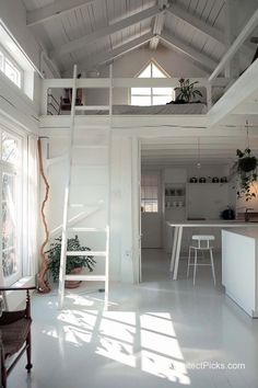 the interior of a house with white walls and ceilings, windows, and furniture in it