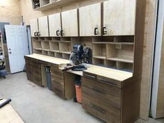 an unfinished workbench in a garage with lots of cabinets and tools on it