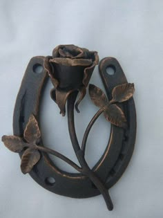 a metal rose with two leaves on it