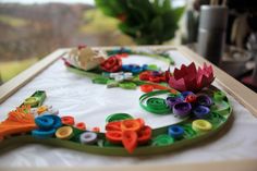 a close up of a piece of art made out of buttons and paper with flowers on it