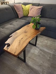 a wooden table sitting on top of a gray couch next to a black sectional sofa