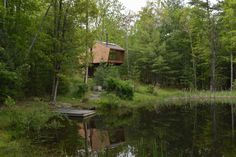 a small cabin sits on the shore of a lake