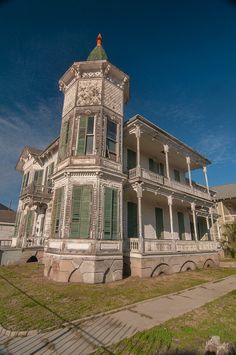 an old victorian house with green shutters on the front