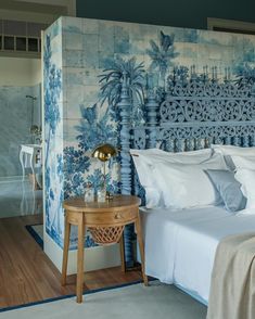 a blue and white bedroom with palm trees painted on the wall behind the headboard