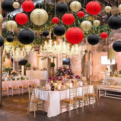 a room filled with lots of tables covered in paper lanterns