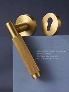 a golden door handle on top of a blue piece of paper next to a key