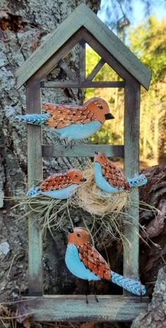 three birds sitting on top of a bird house