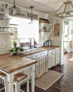 a kitchen with white cabinets and wooden counter tops, along with an island in the middle