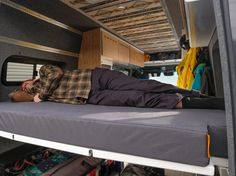 a man laying on top of a bed in the back of a truck