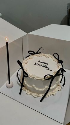 a birthday cake in a box with a lit candle