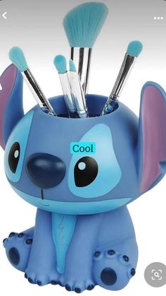 an elephant shaped toothbrush holder with makeup brushes in it's mouth and the lid open