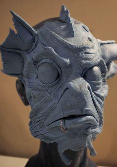 a close up of a statue of a demon with big eyes and an evil look