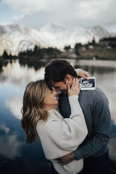 a man and woman standing next to each other near water